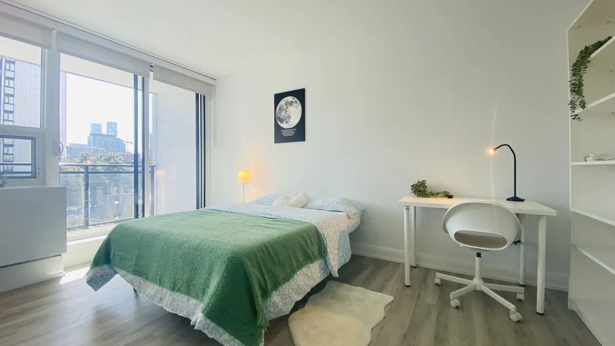 Corner bedroom with a full bed and windows on two walls